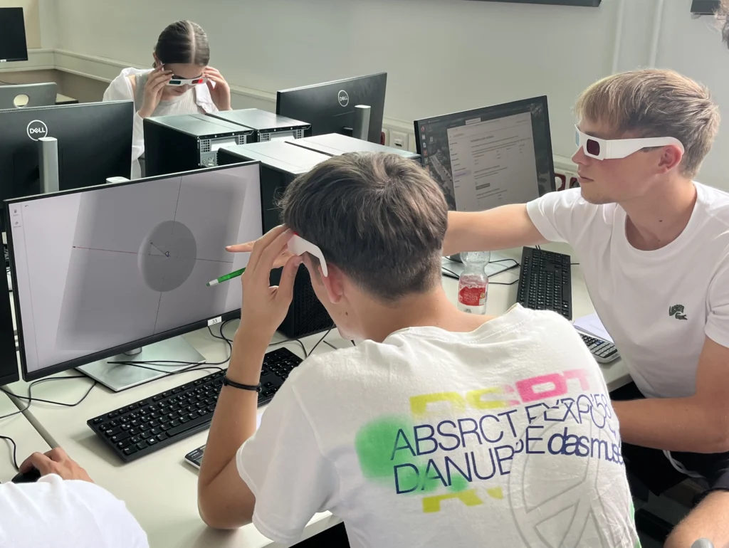 Schülerinnen und Schüler betrachten eine dreidimensionale Darstellung am Computer mit 3D-Brillen